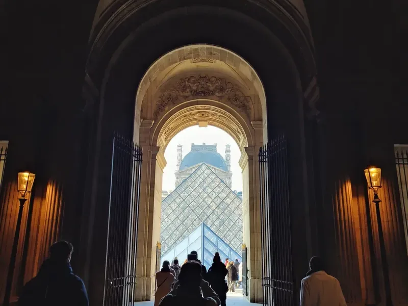 Il passaggio ad arco del Louvre con la piramide di vetro sullo sfondo